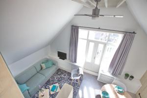 a living room with a blue couch and a window at Studio 45D in Scheveningen