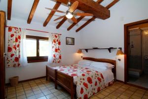 1 dormitorio con 1 cama y ventilador de techo en Agriturismo Il Portico, en Penne