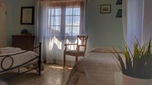 a bedroom with a bed, chair and window at B&B Il Casale delle Pianacce in Castiglione di Garfagnana