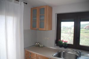 a kitchen with a sink and a window at Olive Tree Cottage in Nea Peramos +40 photos