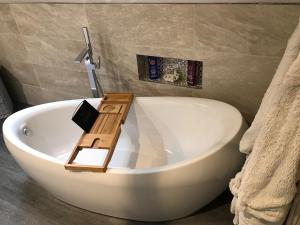 a bathroom with a bath tub with a wooden board on it at Lon y Traeth Bed & Breakfast in Pentraeth