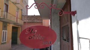 ein rotes Schild, das vom Eingang eines Gebäudes hängt in der Unterkunft The Alley Inn in Santa Maria Capua Vetere