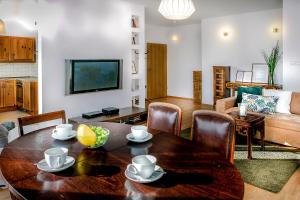 ワルシャワにあるWarsaw Concierge Saxon Apartmentのリビングルーム(テーブル、椅子、ソファ付)