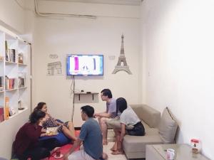 un gruppo di persone seduti in un soggiorno a guardare la TV di MADOR Malang Dorm Hostel a Malang Altre 36 foto