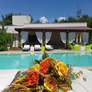 a bouquet of flowers sitting next to a swimming pool at Villa Edda Heated Pool in Galatina