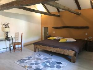 ein Schlafzimmer mit einem Bett, einem Tisch und einem Stuhl in der Unterkunft Domaine d'Alcapiès in Saint-Jean-dʼAlcapiès
