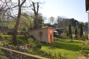 a garden with a small building in the grass at FEWO natuerlich-wolf in Königstein an der Elbe