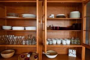 a wooden cabinet filled with dishes and glasses at Marisol Apt Algarve in Armação de Pêra