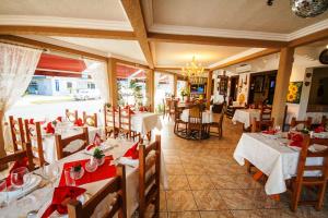 a restaurant with white tables and chairs with red napkins at Hotel Cabana Suiça in Guaratuba