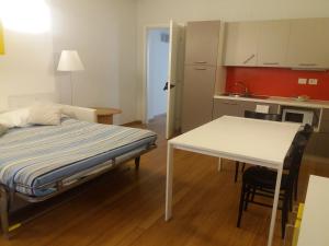 Cette chambre comprend un lit, une table et une cuisine. dans l'établissement Luoghi Comuni Porta Palazzo, à Turin