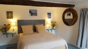 una camera con un letto con due lampade e uno specchio di L'Oliveraie des 3 Mas a Saint-Michel-de-Llotes