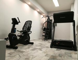 a room with a gym with a chair and a treadmill at Erato Hotel in Agia Marina Aegina