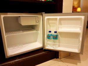an open refrigerator with two bottles of water in it at Cozy Escape @ Gold Coast Morib in Morib