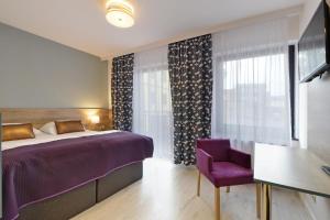 een slaapkamer met een paars bed en een paarse stoel bij Luna in Zielona Góra