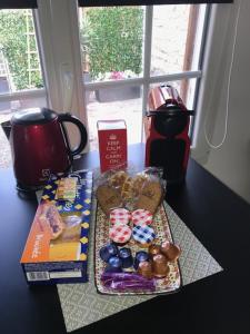 einen Tisch mit einem Tablett mit Gebäck und anderen Snacks in der Unterkunft Studio centre ville in Compiègne