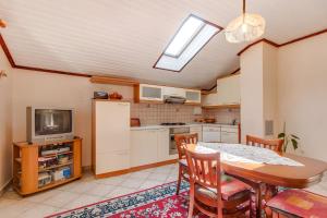 a kitchen with a dining room table and a tv at Apartment Danilo in Mali Lošinj