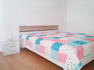a bedroom with a bed with a quilt on it at Apartment Kurelic in Rab