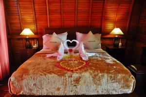 Un dormitorio con una cama con dos cisnes. en Petak Cottage, en Nusa Penida