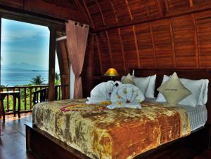 1 dormitorio con 1 cama y vistas al océano en Petak Cottage, en Nusa Penida