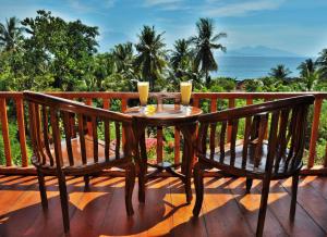 una mesa y sillas en una terraza con vistas al océano en Petak Cottage en Nusa Penida
