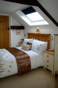 1 dormitorio con 1 cama grande y tragaluz en Olde Farm Holiday Cottages en Banham