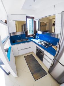 a kitchen with white cabinets and blue counters at Leukasia in Marina di Pescoluse