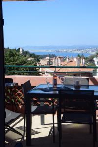 una mesa y sillas en un balcón con vistas en Agréable 3 pièces climatisé avec vue mer et parking en Villefranche-sur-Mer