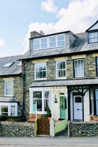 a stone house with a green and white door at Fellview Guest House in Bowness-on-Windermere