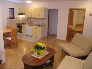 a kitchen and living room with a table and a couch at Villa Maja in Baška