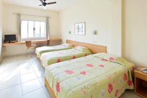 1 dormitorio con 2 camas, escritorio y mesa en Kyoto Hotel en São Paulo