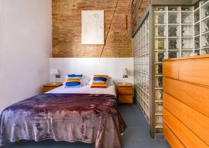 ロスピタレート・デ・リョブレガートにあるCamp Nou Apartmentのレンガの壁、ベッド付きのベッドルーム1室