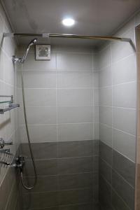 a shower in a bathroom with a tile wall at Chalet Pkhelshe in Kazbegi