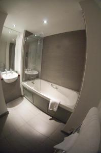 a bathroom with a bath tub and a sink at Queens Hotel & Spa in Brighton & Hove
