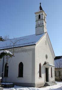 eine weiße Kirche mit einem Turm auf dem Dach in der Unterkunft Projekt GASTRAUM in Illertissen