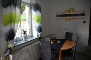a table and chair in a room with a window at AktivQuartier Mühlviertel Apartment in Oepping