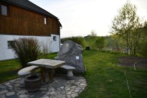 a stone bench sitting in the grass next to a building at AktivQuartier Mühlviertel Apartment in Oepping