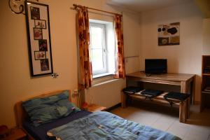 a bedroom with a bed and a desk with a computer at AktivQuartier Mühlviertel Apartment in Oepping