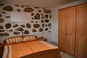 a bedroom with a bed and a rock wall at AktivQuartier Mühlviertel Apartment in Oepping +6 photos