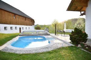 a swimming pool in a yard next to a building at AktivQuartier Mühlviertel Apartment in Oepping