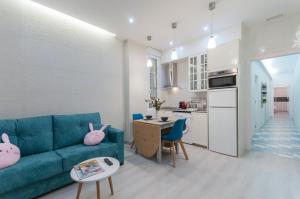 a living room with a blue couch and a kitchen at Charming Puerta del Sol Center in Madrid