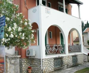 a building with arches and a balcony at Lena Blue Sea Apartments in Kalami