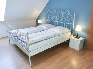 a white bed with a blue headboard in a bedroom at Appartement an der Seefelder Mühle in Seefeld