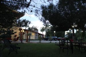 a yard with benches and a building with cars parked at Rancho El Campanario en La Ruta del Vino in Valle de Guadalupe