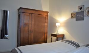 um quarto com um armário de madeira ao lado de uma cama em Aan 't kapelke em Valkenburg
