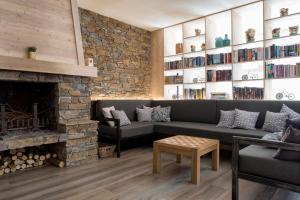 a living room with a couch and a fireplace at Auberge La Douce Montagne in Allemont