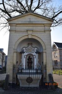 a building with a gate with a statue in it at Aan 't kapelke in Valkenburg