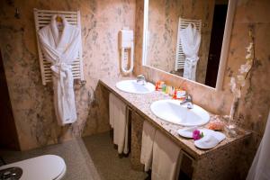 a bathroom with two sinks and two mirrors at Suite Hotel S'Argamassa Palace in Santa Eularia des Riu