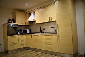 a kitchen with wooden cabinets and a microwave at Enrosadira in Molveno
