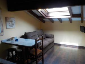 uma sala de estar com um sofá e uma mesa em Apartamentos Rurales La Husteriza em Ruenes