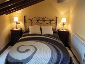 um quarto com uma cama grande e 2 candeeiros em Apartamentos Rurales La Husteriza em Ruenes